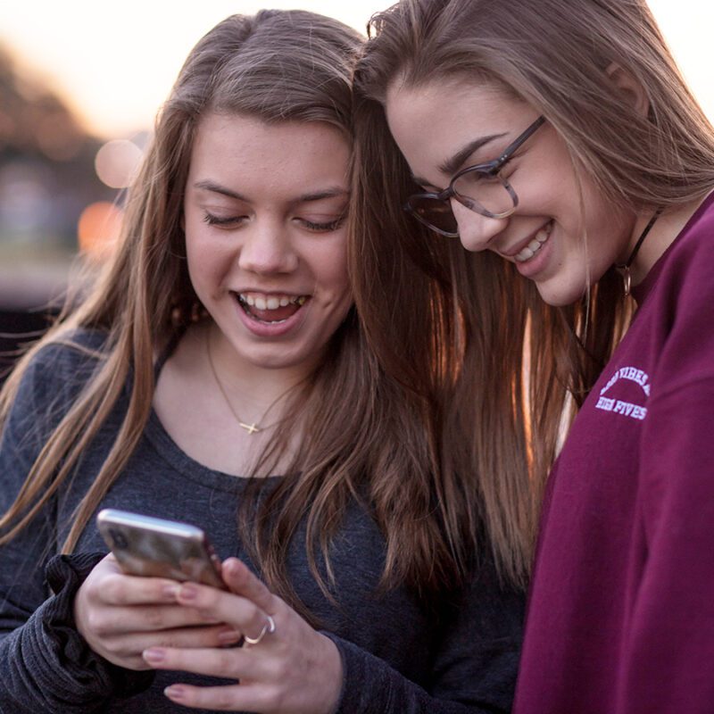 Picture of two teenagers looking at a mobile phone