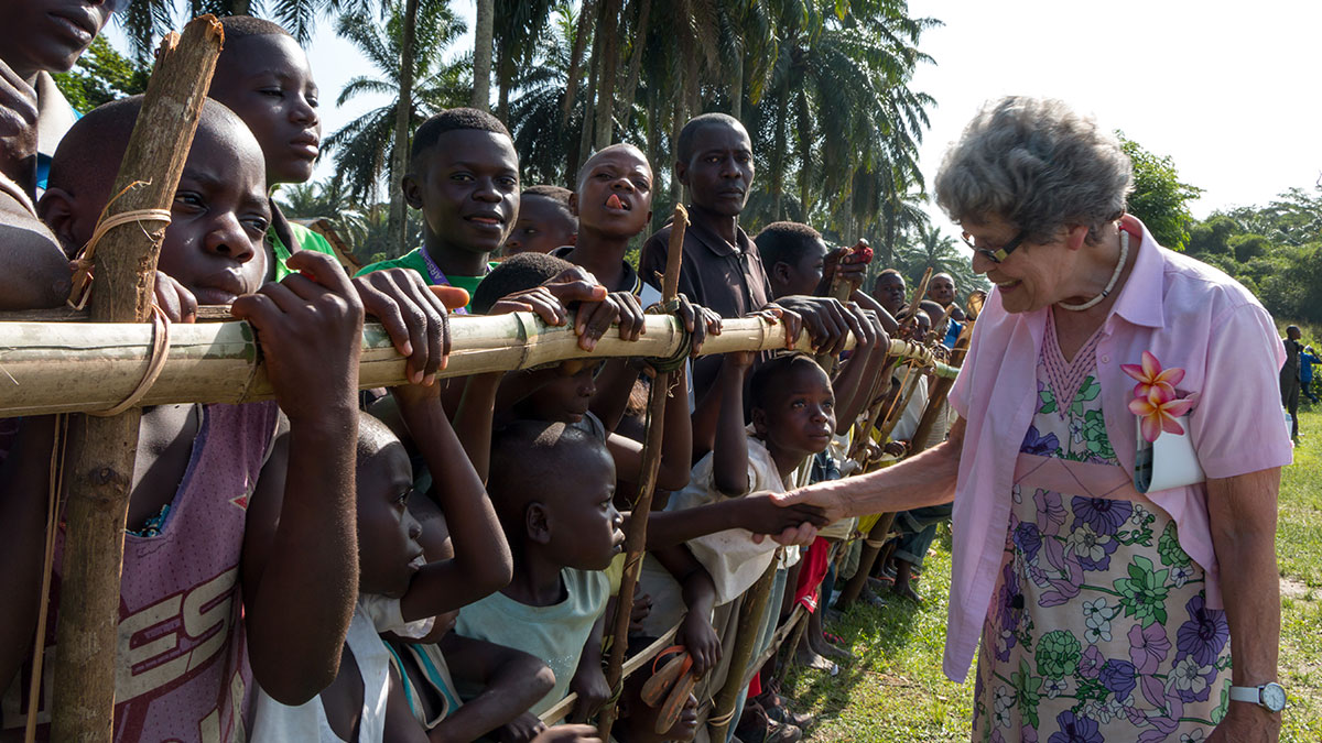 Maud Kells welcomes in Mulita in DRC after arriving on an MAF plane. Photo by Mark & Kelly Hewes