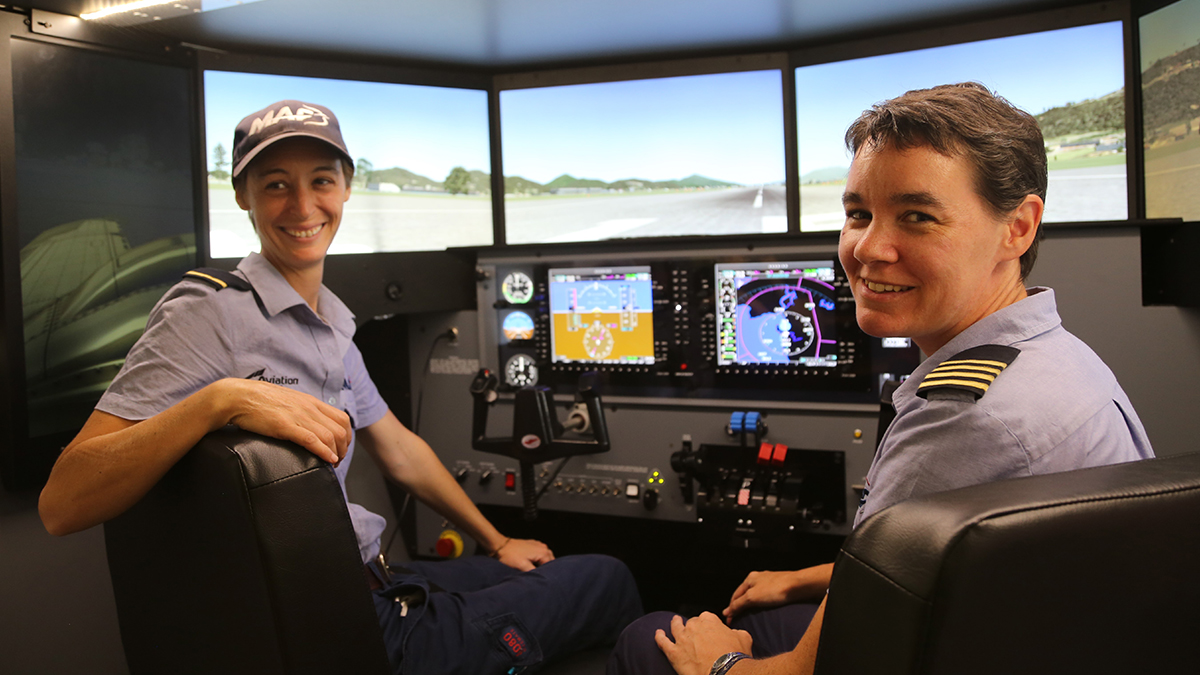 Bridget trains student, Kori Shinn (L), on Redbird flight simulator at MAF Mareeba Flight Training Centre 