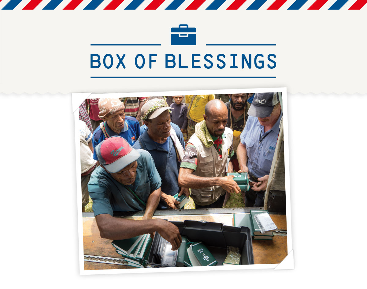 Picture of bibles being handed out from a MAF plane with the title "Box of blessings"