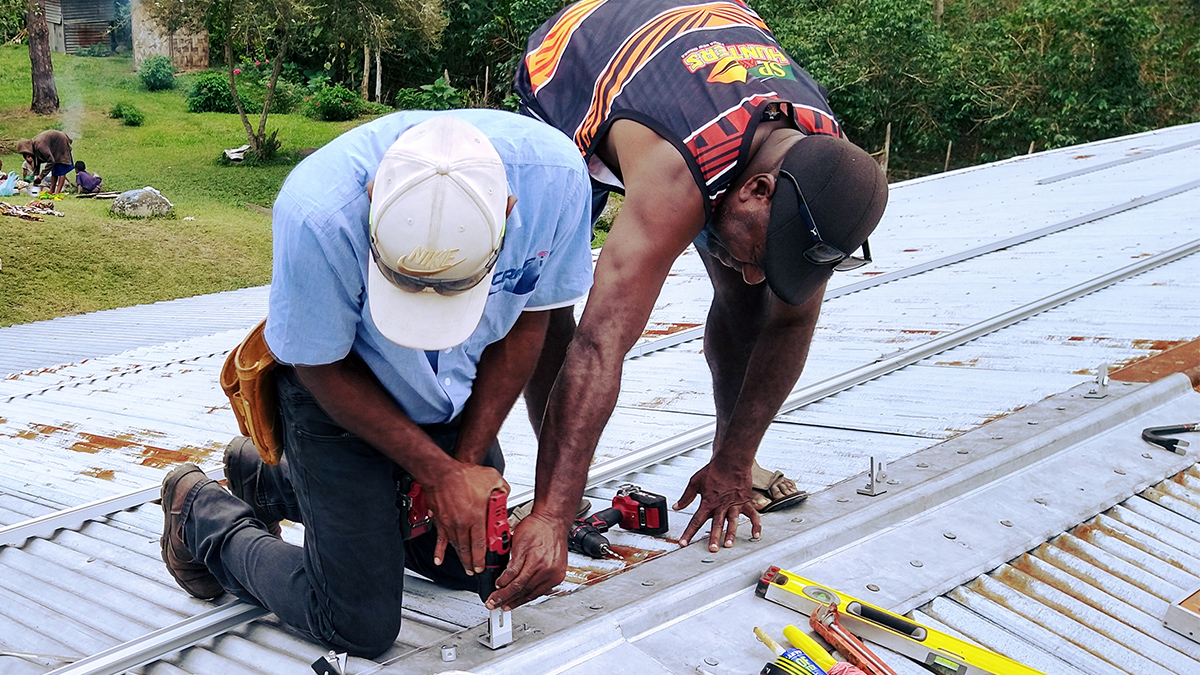 MAF Technologies PNG electrician, Brian Baimako (L) and colleague, hard at work before it gets dark