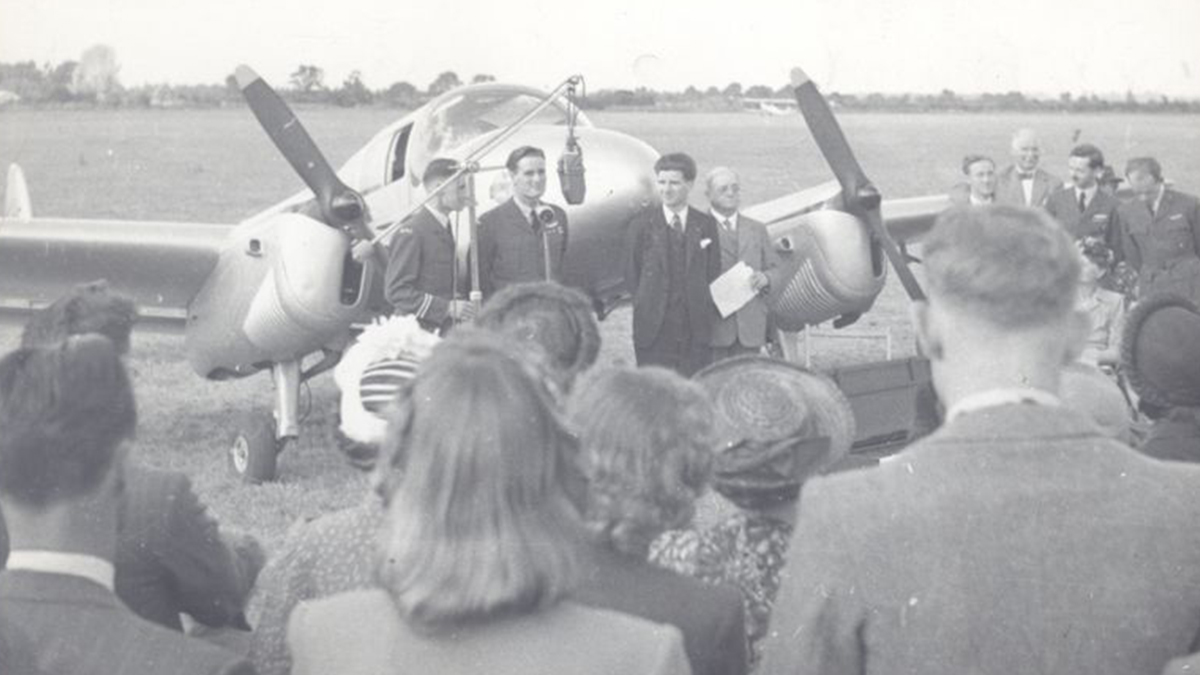August 1947 dedication service for the 'Mildmay Pathfinder' – MAF’s first Miles Gemini aircraft - at Broxbourne Airport, Hertfordshire. MAF co-founder Murray Kendon (far left), Jack Hemmings (speaking) & MAF co-founder Stuart King (far right in dark tie with moustache).
