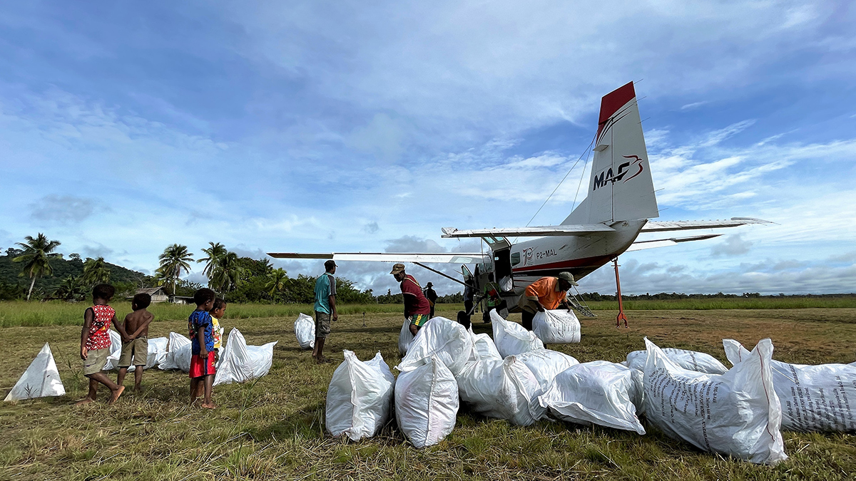 MAF delivers bales of nets to Edwaki Airstrip overlooked by curious children