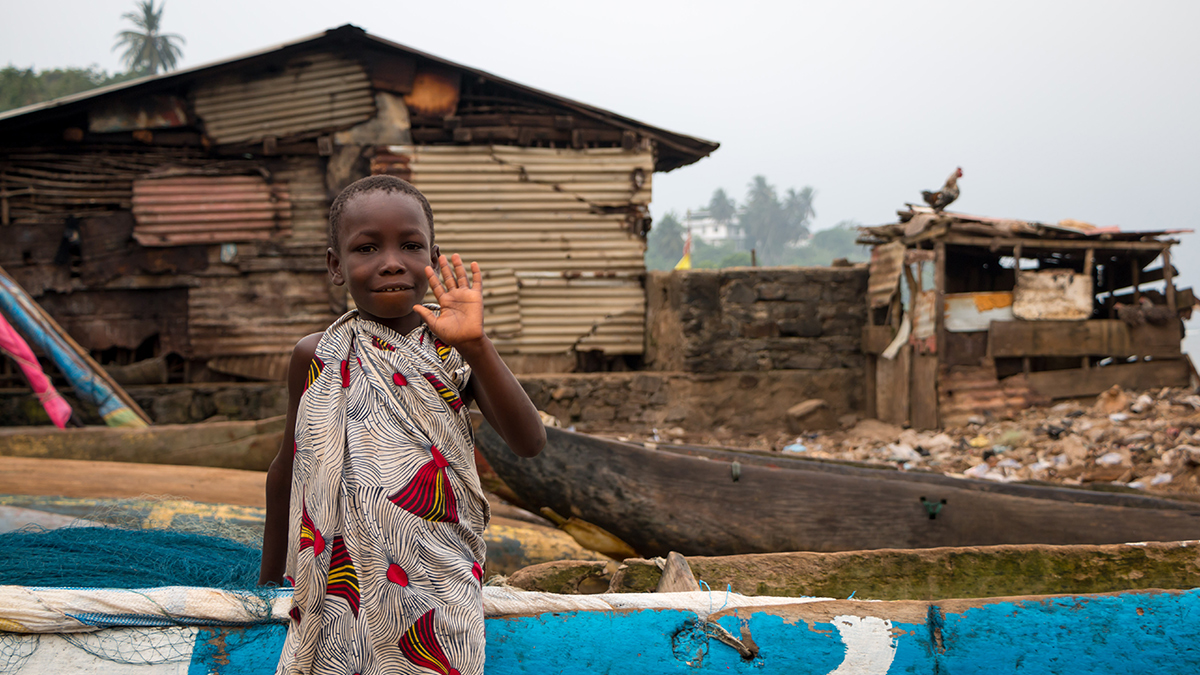 A child surrounded by run down shacks in Maryland County, Liberia