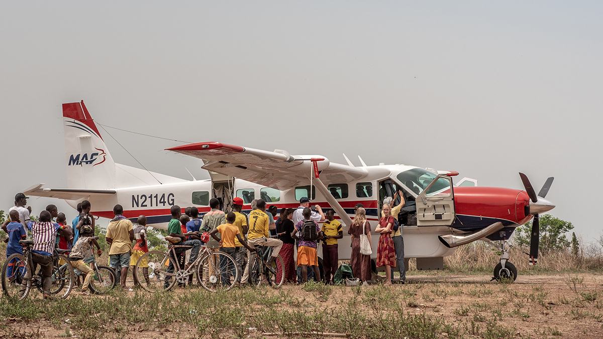 Excited locals and missionaries meet the plane in Kissidougou