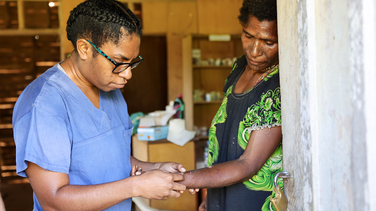 Dr Rebecca Williams examines a woman’s arm during her visit to Malaumanda