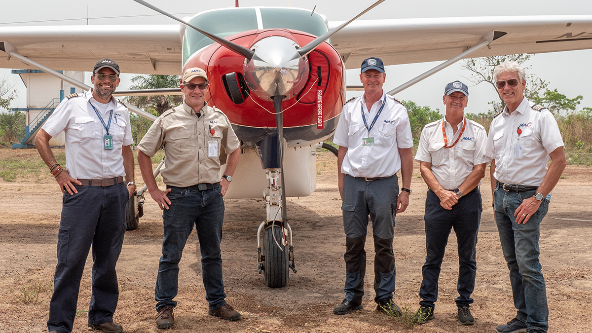 MAF pilots in Guinea have to undergo special training & auditing before they can officially fly. (L to R: pilot Dave Forney, director of ops Stan Unruh, pilot Roy Rissanen, Guinea country director Emil Kundig & MAF US chief pilot Brian Shepson on Kissidougou runway, Guinea