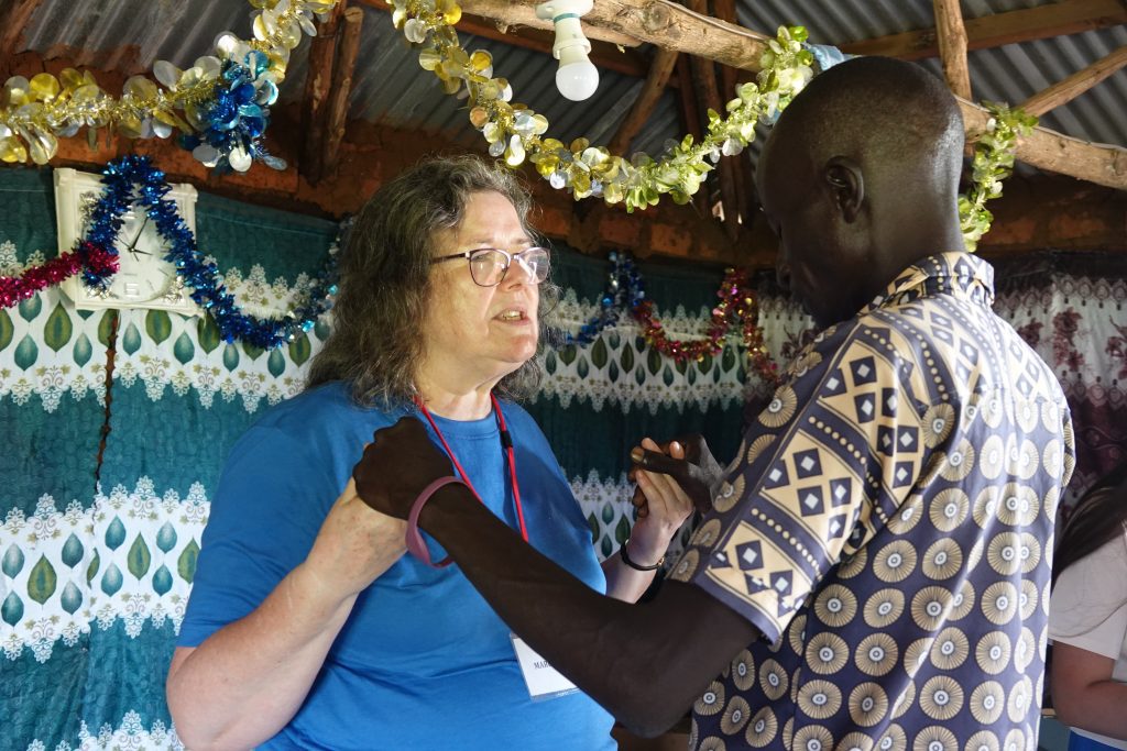 A Flame International volunteer works with one of the participants (credit: Damalie Hirwa)