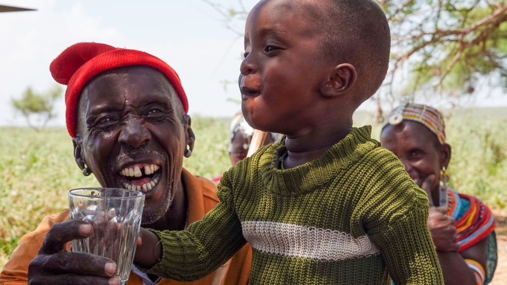 A little boy enjoys drinking a glass of clean, filtered water (credit: Paula Alderblad)